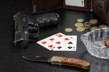 Hanster style: gun card knife and money on a black table