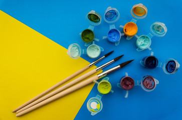 Flat lay composition with different acrilic or oil paints and brushes on grunge background.