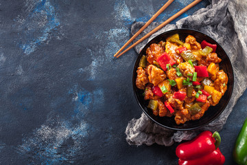 Sweet and sour chicken with colorful bell pepper on a plate - 261963114