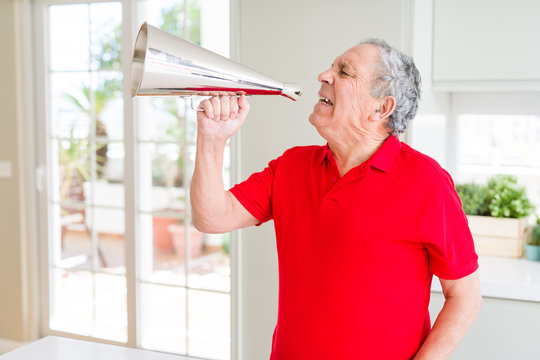 Senior man shouthing excited through vintage metal megaphone