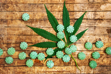 Cannabis bonbons and marijuana leafs on a table