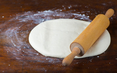 fresh raw dough and rolling pin isolated on white background