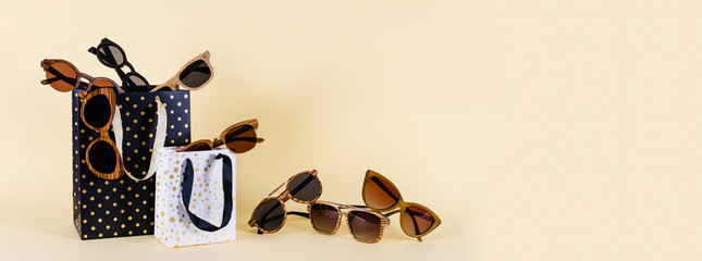 Sunglasses sale concept. Wooden sunglasses of different design on yellow background. Copy space....