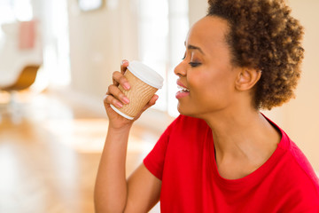 Beautiful young african american woman drinking a coffee in a take away paper cup