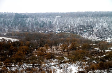 Fototapeta na wymiar Winter, view from a high mountain. Forest and village in the distance