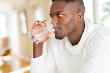 Naklejka na ściany i meble Young african american man drinking a fresh glass of water