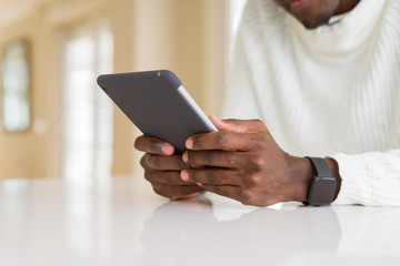 Close up of african business man using touchpad tablet, working sitting on a desk