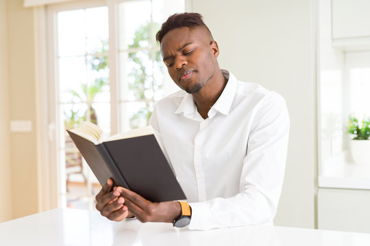 Young african man reading a book, studying for univeristy