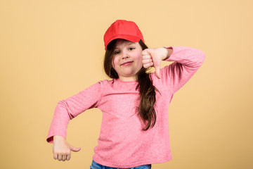 Cutie in cap. Kids fashion. Girl cute child wear cap or snapback hat beige background. Little girl wearing bright baseball cap. Modern fashion. Stylish accessory. Feeling confident with this cap