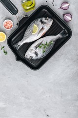 Fresh raw dorado fish with spices. Ingredients for cooking in cast iron grill pan.