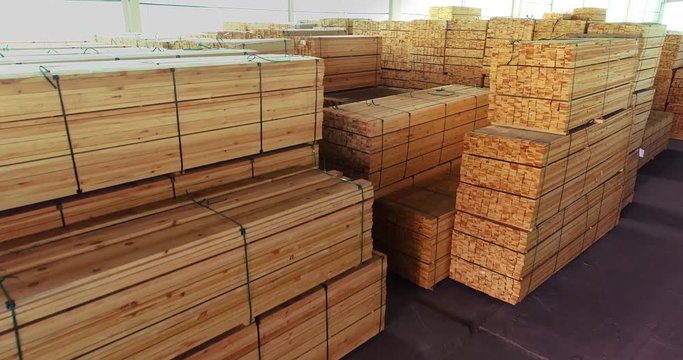 A large warehouse of timber materials, neatly folded timber in a sawmill warehouse, warehouse of wood