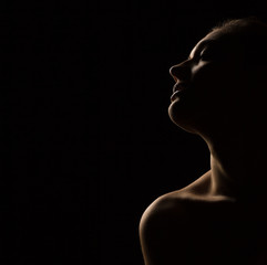 portrait silhouette of young sensual woman on dark background