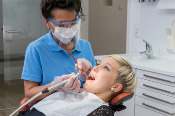 Patientin bekommt eine professionelle Zahnreinigung