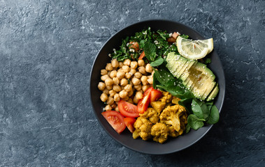 Buddha bowl Vegetarian healthy balanced food Aloo-gobi, chickpeas, tomato, avocado, tabule salad...