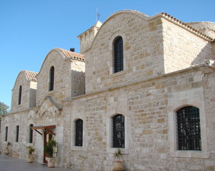 View from the bottom of the medieval temples in the ancient part of the city under the rays of the evening sun against the background of a cloudy blue sky.