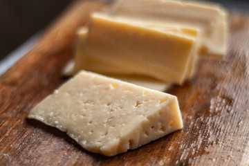 sliced cheese on a chopping wooden board