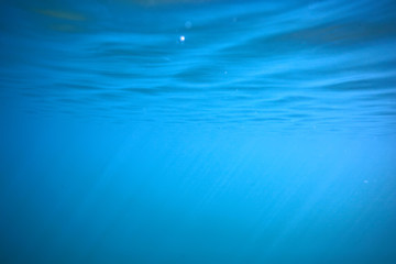 ocean water blue background underwater rays sun / abstract blue background nature water