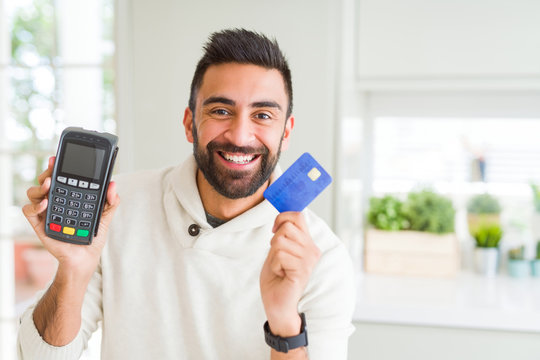 Business man smiling and holding point of sale terminal and credit card, contacless transaction