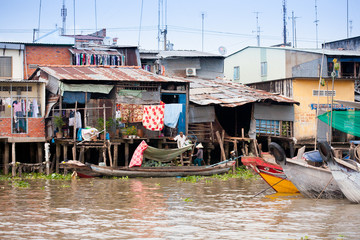 Fototapeta na wymiar JAN 28 2014 - MY THO, VIETNAM - Houses by a river, on JAN 28, 2014, in Mekong Delta, Vietnam