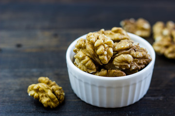Delicious arrangement of walnuts in a bowl on a wooden table. Healthy food and snack, organic vegetarian food