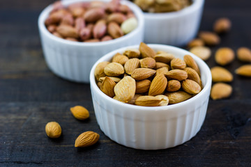 Tasty nuts arrangement in a bowl on a wooden table. Healthy food and snack, organic vegetarian food. Walnut, almond, peanut