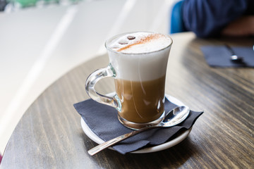 Close up of cup of capuchino coffee with foam at restaurant