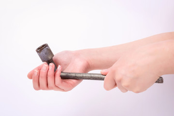 Fototapeta premium Wheel wrench in hand of the girl. Symbol of hard work, feminism and labor day. Isolate on white background.