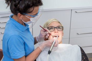 Frau beim Zahnarzt, bekommt eine professionelle Zahnreinigung