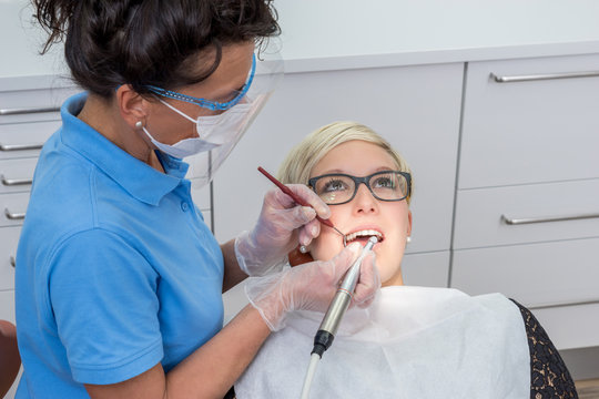 Frau beim Zahnarzt, bekommt eine professionelle Zahnreinigung