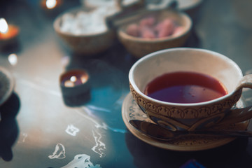 a cup of red tea and sugar cubes with different tastes, handmade, on the glass table, eastern tea ceremony. dark. Selective focus, copy space, Hookah concept, making clouds, Arabian interior.