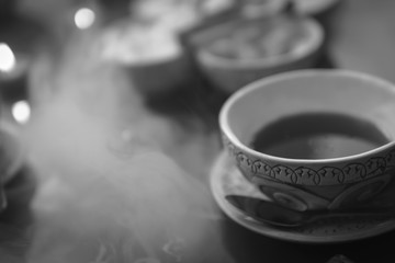 a cup of red tea and sugar cubes with different tastes, handmade, on the glass table, eastern tea ceremony. dark. Selective focus, copy space, Hookah concept, making clouds, , black and white