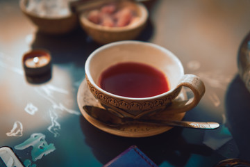 a cup of red tea and sugar cubes with different tastes, handmade, on the glass table, eastern tea ceremony. dark. Selective focus, copy space, Hookah concept, making clouds, Arabian interior.