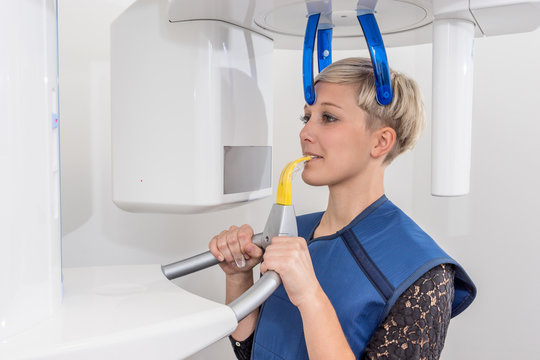 Patientin beim Zahnarzt wird mit einem technischen Ger&auml;t untersucht