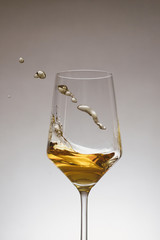 glass of white wine with wave on white background