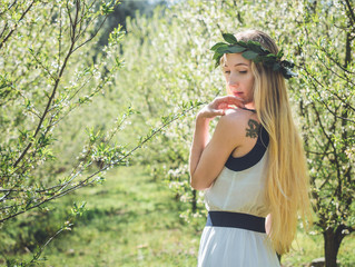 Young beautiful smiling woman in spring blossom trees.