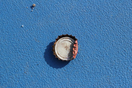 Chapa de bebida sobre el asfalto