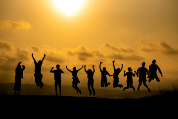 Fototapeta na wymiar Silhouette of happy business human team making high hands over head in sunset sky evening time background for business teamwork concept and freedom