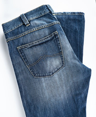 folded blue men's jeans on a white background