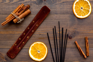 air freshener sticks with cinnamon and orange on wooden background top view