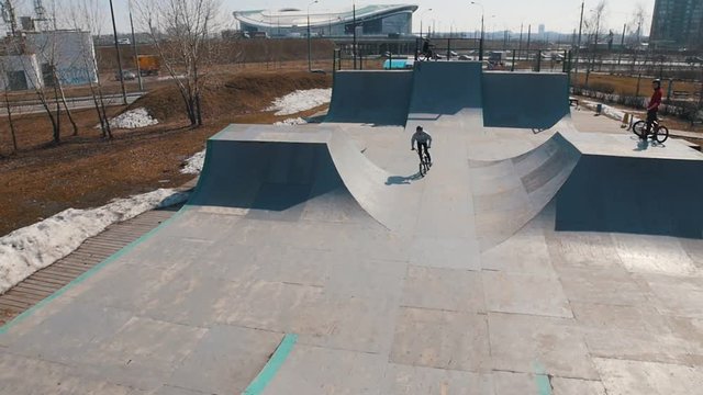 A talanted man on a bicycle performing tricks in the skatepark