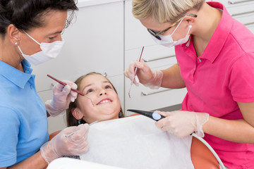 Mädchen wartet entspannt lächelnd beim Zahnarzt auf die Untersuchung