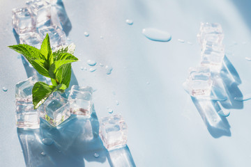 Ice cube with mint on blue. Summer fresh concept.