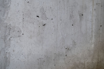 Concrete wall with stains, cracks and holes