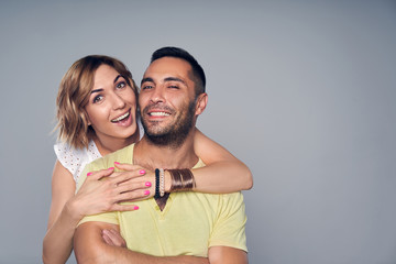 Happy couple in studio laughing over grey