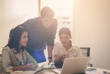 Fototapeta premium Businesspeople discuss a project ;A woman sitting at the computer shows infographics to partners; An example of good relations at work