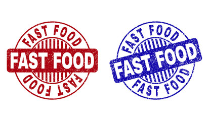Grunge FAST FOOD round stamp seals isolated on a white background. Round seals with grunge texture in red and blue colors. Vector rubber watermark of FAST FOOD title inside circle form with stripes.