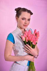 girl with a bouquet of tulips on a pink background