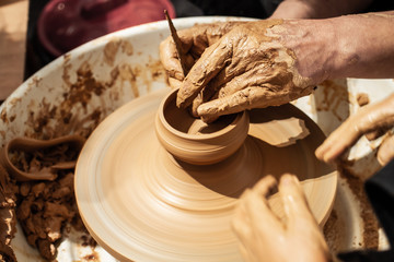 Expert potter teach a child to work on potter wheel