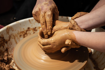 Expert potter teach a child to work on potter wheel