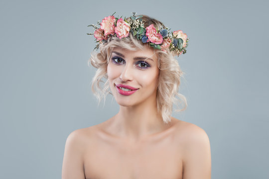 Portrait of fashion woman with flowers. Cheerful model with short hair and makeup smiling